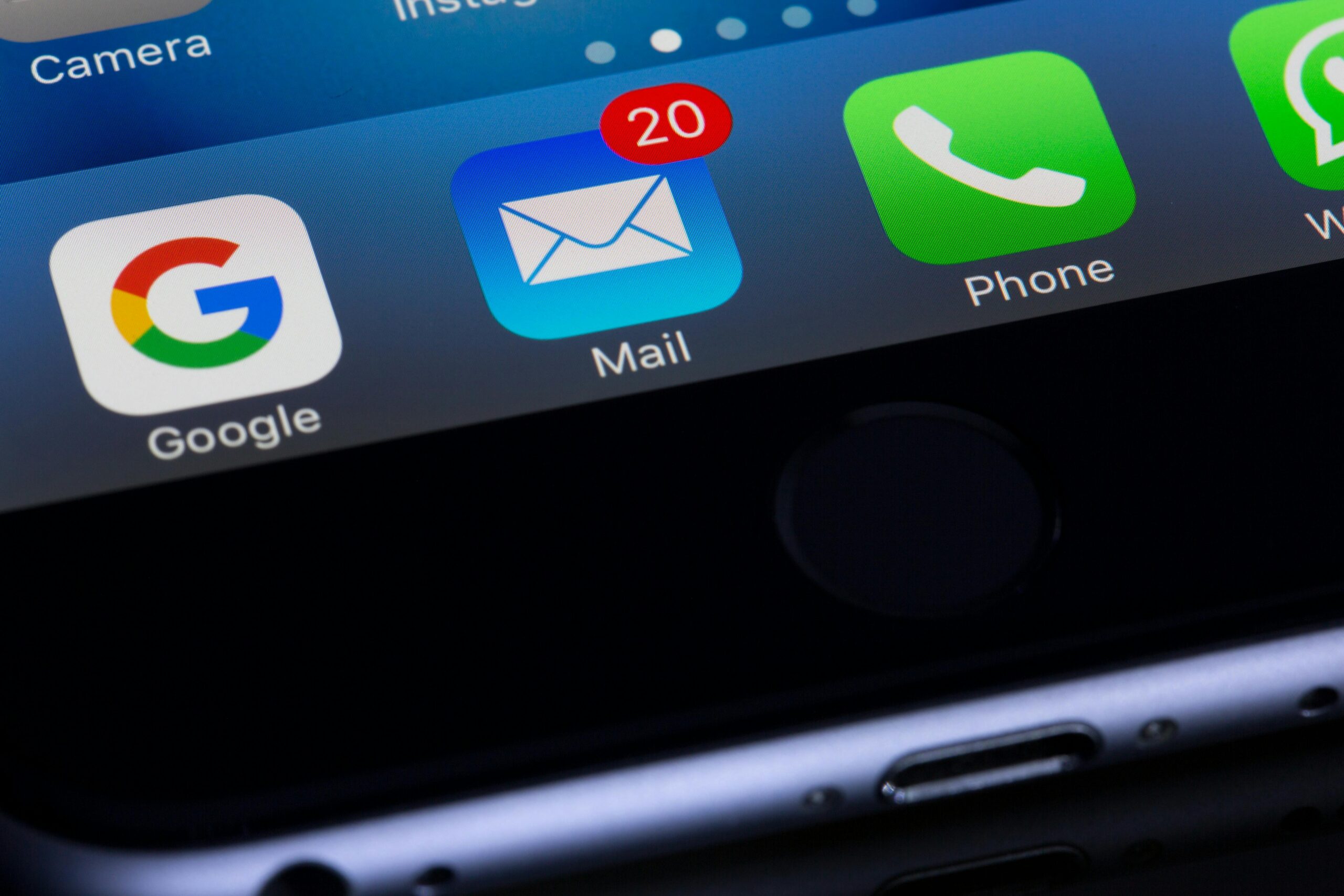 email marketing agency A close-up photo of a smartphone displaying popular apps like Google and Mail.